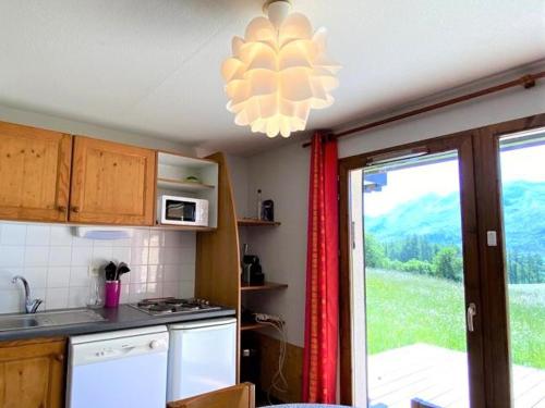 une cuisine avec évier et four micro-ondes ainsi qu'une fenêtre dans l'établissement Appartement rénové 6 pers, terrasse, parking, local ski - FR-1-504-150, à Saint-Étienne-en-Dévoluy