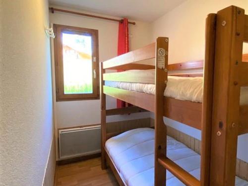 Cette petite chambre dispose de 2 lits superposés et d'une fenêtre. dans l'établissement Appartement rénové 6 pers, terrasse, parking, local ski - FR-1-504-150, à Saint-Étienne-en-Dévoluy