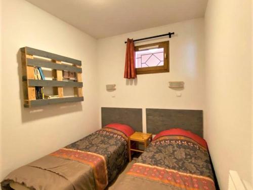Duas camas num pequeno quarto com uma janela em Appartement La Joue du Loup, 2 pièces, 6 personnes - FR-1-504-485 em Le Dévoluy