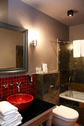 a bathroom with a red sink and a shower at Hotel Browar Kościerzyna in Kościerzyna