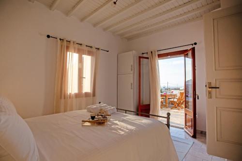 een slaapkamer met een bed en een deur naar een patio bij Villa Dimitra in Ano Mera