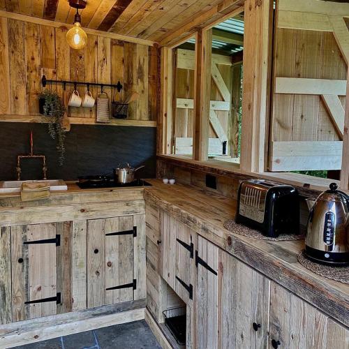 cocina con armarios de madera y encimera en Bee Bole Cabin en Monmouth