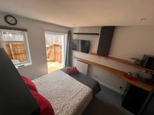 a small bedroom with a bed and a window at Larmins Room in Milton Keynes