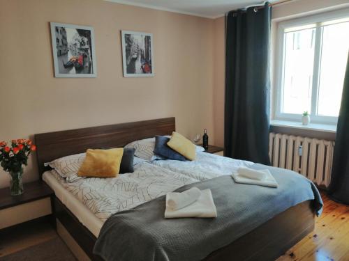 a bedroom with a bed with two towels on it at Cicha Przystań Apartament Starówka in Kołobrzeg