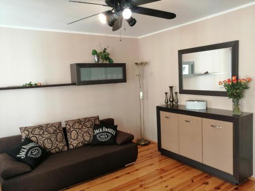 a living room with a couch and a mirror at Cicha Przystań Apartament Starówka in Kołobrzeg
