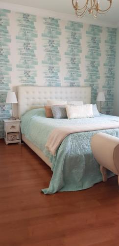 Un dormitorio con una cama y una lámpara de araña. en Casa Joaninha, en Olhão