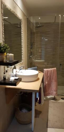 Un baño con lavabo y un espejo grande. en Casa Joaninha, en Olhão
