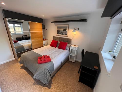 a bedroom with a bed with a red bag on it at Central Room in Milton Keynes