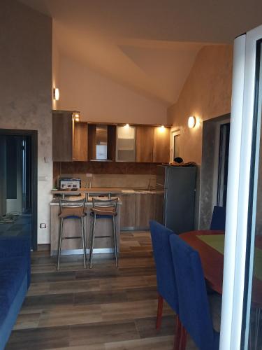 a kitchen with a table and some blue chairs and a table at Apartments with sea view in Prcanj in Kotor