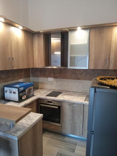 a kitchen with stainless steel appliances and wooden cabinets at Apartments with sea view in Prcanj in Kotor