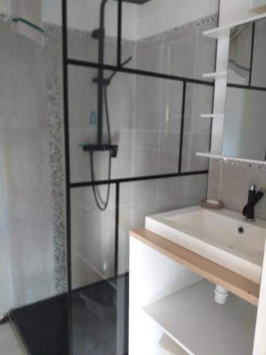 Un baño blanco con lavabo y ducha. en A 350m de la plage, en Fouesnant