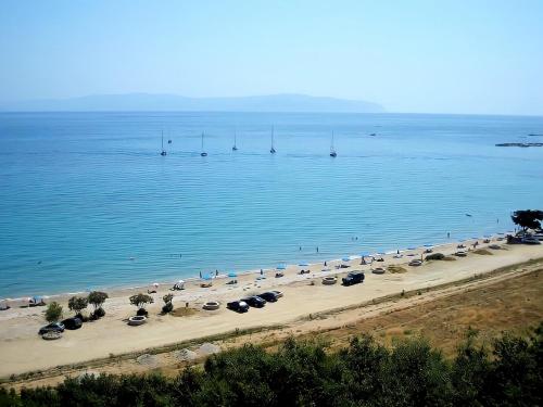 a beach with many umbrellas and boats in the water at Thalia's place in Áno Kateliós