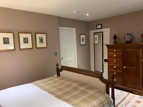a bedroom with a bed and a dresser and a mirror at Maplestone in Shepton Mallet