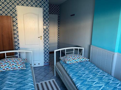2 łóżka pojedyncze w pokoju z drzwiami w obiekcie U Jana w mieście Przemyśl