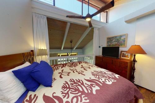 a bedroom with a large bed with blue pillows at Magnificent Sunsets and Ocean views at Luana Kai in Kihei