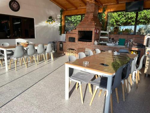 a dining room with a table and chairs and a fireplace at Pensiunea Prestige House in Curtea de Argeş