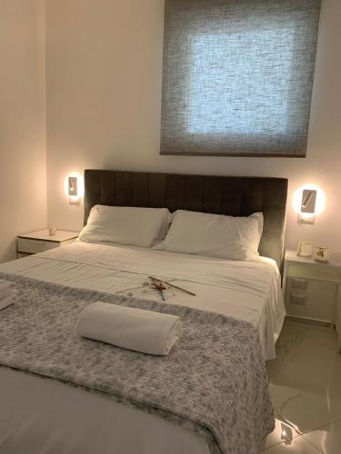a bedroom with a large bed with a cross on it at Nautilus Room&Apartment in Polignano a Mare