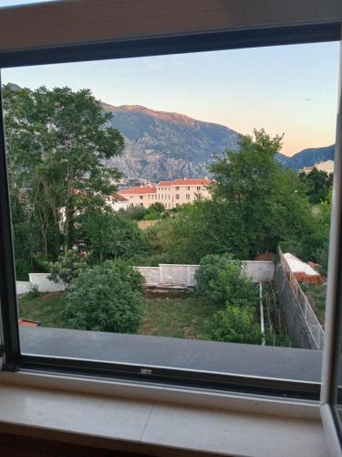 a window with a view of a building at Apartments with sea view in Prcanj in Kotor