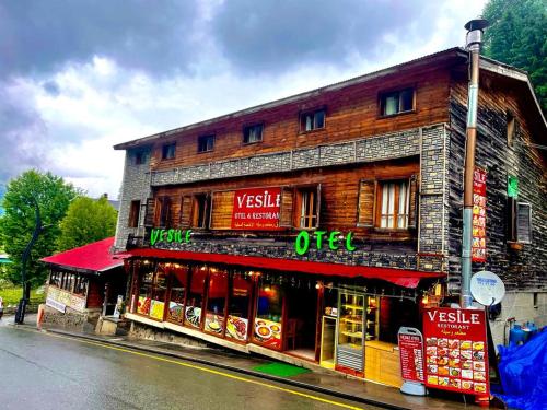 a building with signs on the side of a street at Ayder Vesile Otel in Ayder Yaylasi