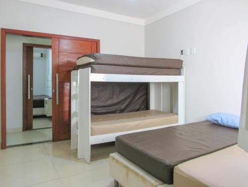 מיטה או מיטות קומותיים בחדר ב-Lazer completo ao lado da praia em Porto Seg - BA
