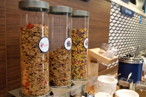 four glass containers filled with different types of cereal at Holiday Inn Express & Suites - Edmonton SW – Windermere by IHG in Edmonton
