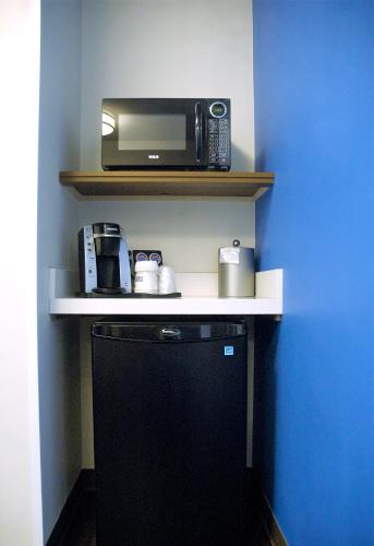 a kitchen with a microwave and a toaster oven on a shelf at Holiday Inn Express & Suites - Edmonton SW – Windermere by IHG in Edmonton