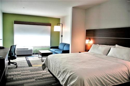 a hotel room with a bed and a desk and a chair at Holiday Inn Express & Suites - Edmonton SW – Windermere by IHG in Edmonton