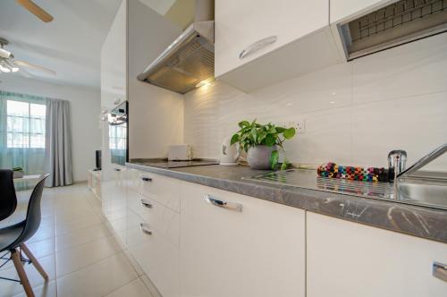グジラにあるAzure Haven - Gzira Apartments and Penthouse By ShortLetsMaltaの白いキャビネットとシンクのあるキッチン