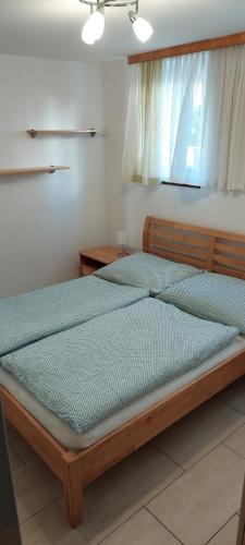 sypialnia z dużym drewnianym łóżkiem i oknem w obiekcie Apartment Hüttner w mieście Gmunden