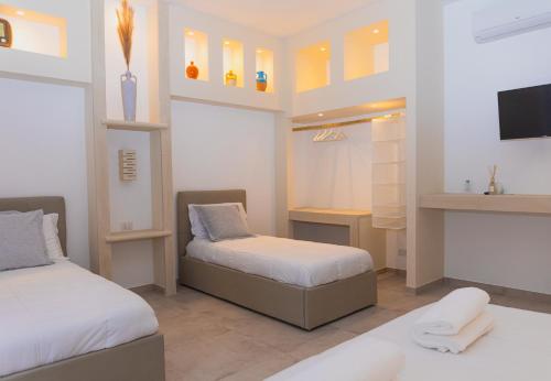 una camera con due letti e una tv di Villa Padula a Sogliano Cavour