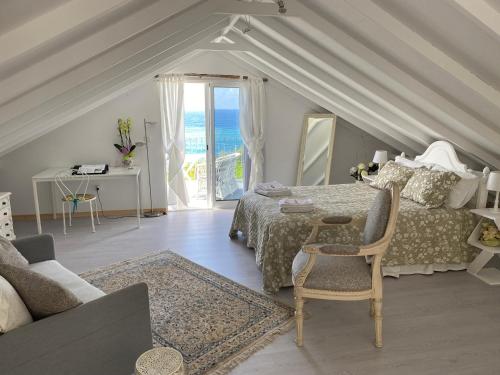 - une chambre avec un lit et une table avec une chaise dans l'établissement Ocean Garden, 4 units by the ocean, à São Vicente