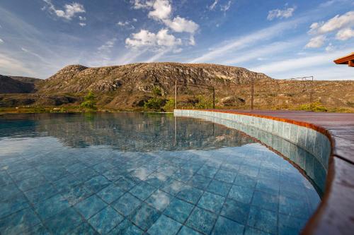a pool of water with a mountain in the background at Sitio Jatoba/Lapinha da Serra in Santana do Riacho