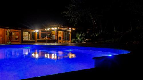 a swimming pool at night with a house at Sitio Jatoba/Lapinha da Serra in Santana do Riacho