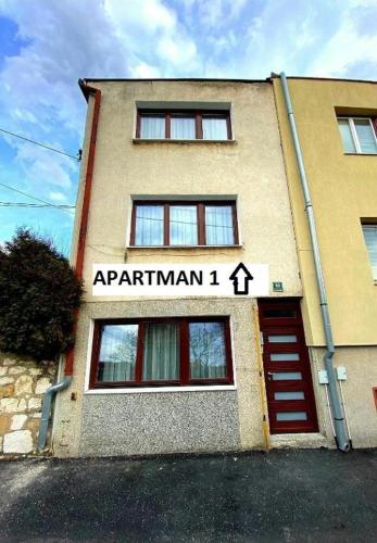a building with a red door and a sign on it at Apartman Slatki dom 1 in Sarajevo