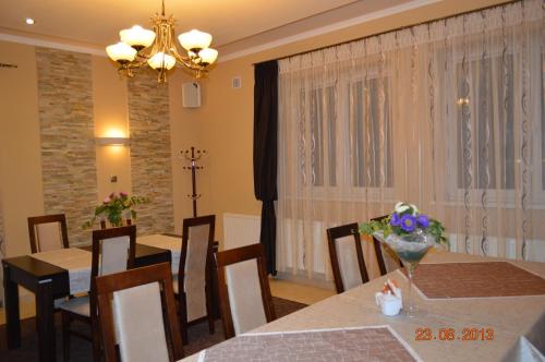 een eetkamer met een tafel, stoelen en een kroonluchter bij Zajazd Złota Podkowa in Wrocki