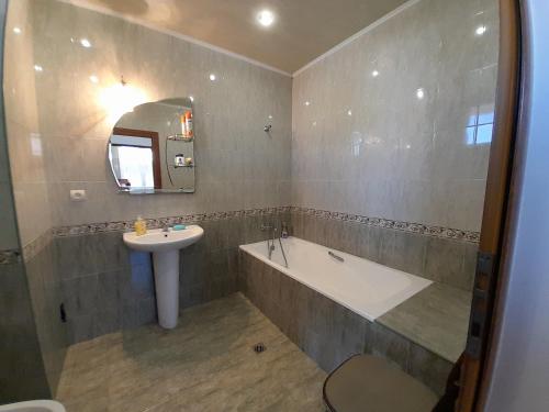 y baño con bañera, lavamanos y bañera. en Melkonyan's home en Gyumri