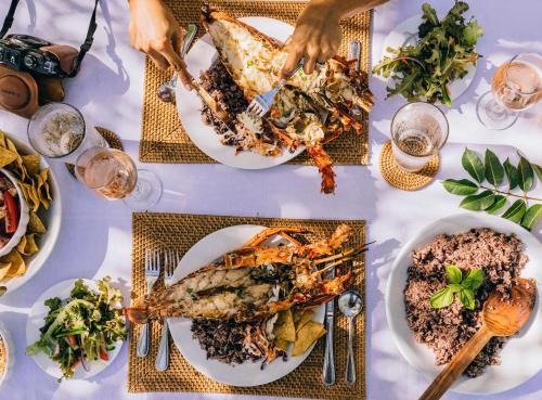a table with plates of food on it at Turtle Inn by Francis Ford Coppola in Placencia Village