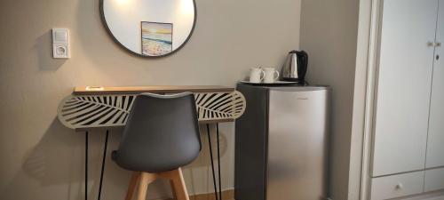a desk with a chair and a mirror on a wall at ILAIRA in Skala Eresou