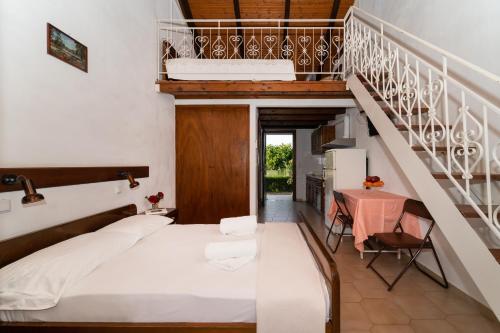 a bedroom with a bed and a staircase with a table at Ilias Apartments in Methoni