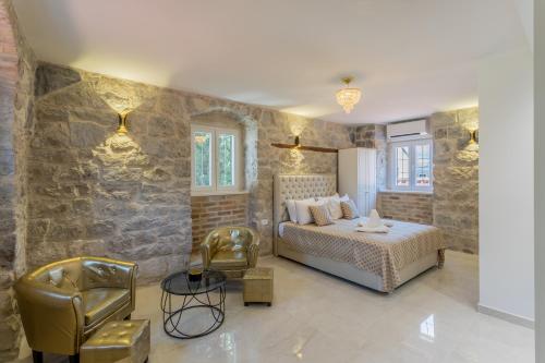 een slaapkamer met een bed en een stenen muur bij Villabella Luxury Rooms in Split