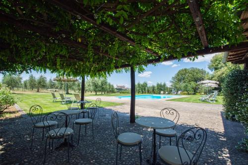 a patio with tables and chairs and a pool at Villa Monteporzano in Orvieto