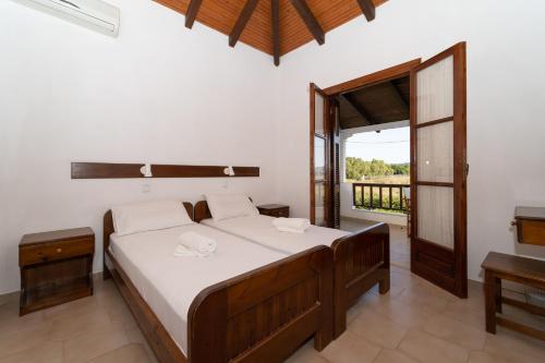 a bedroom with a bed and a balcony at Ilias Apartments in Methoni