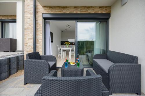 a patio with two chairs and a table at Dwupoziomowy Apartament z Parkingiem - Taras i Balkon - 3 Sypialnie by Renters in Rewal