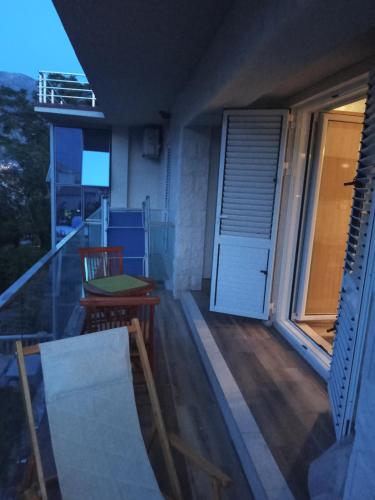 a balcony with a door and a table and a chair at Apartments with sea view in Prcanj in Kotor