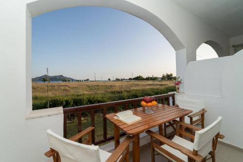 a table and chairs on a balcony with a view of a field at Ilias Apartments in Methoni