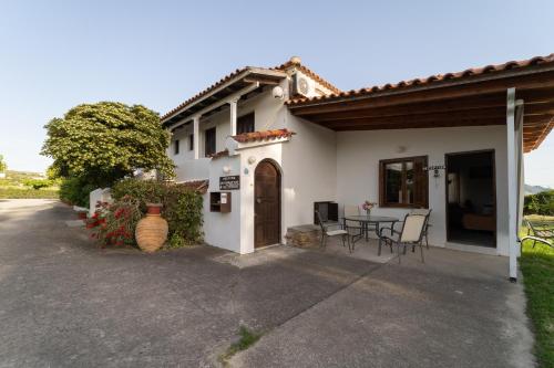 a house with a table and chairs in front of it at Ilias Apartments in Methoni