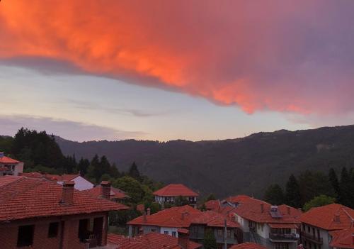a storm cloud over a village with houses and roofs at Apostolos Hotel in Metsovo