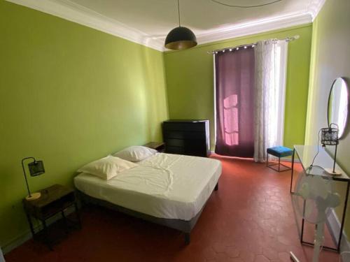 Cette chambre verte comprend un lit et une fenêtre. dans l'établissement SETE : Hyper centre piéton Haussmannien 2, à Sète