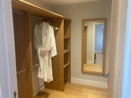 a bathroom with a robe hanging on a closet at The Oaks Stable cottage in Haughley