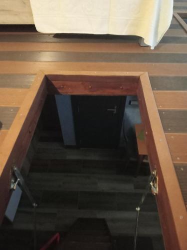 a small door in the floor of a room with stairs at Apartments with sea view in Prcanj in Kotor